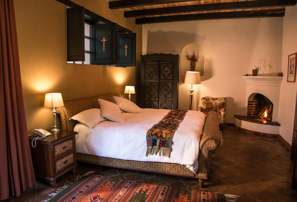 um quarto com uma cama grande e uma lareira em Guayaba Inn Boutique Hotel em San Cristóbal de Las Casas