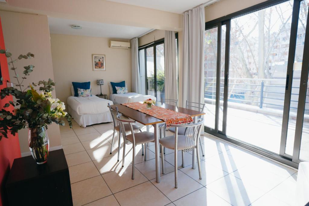 un salon avec une table et des chaises ainsi qu'une chambre dans l'établissement Uvas Apart Hotel, à Mendoza