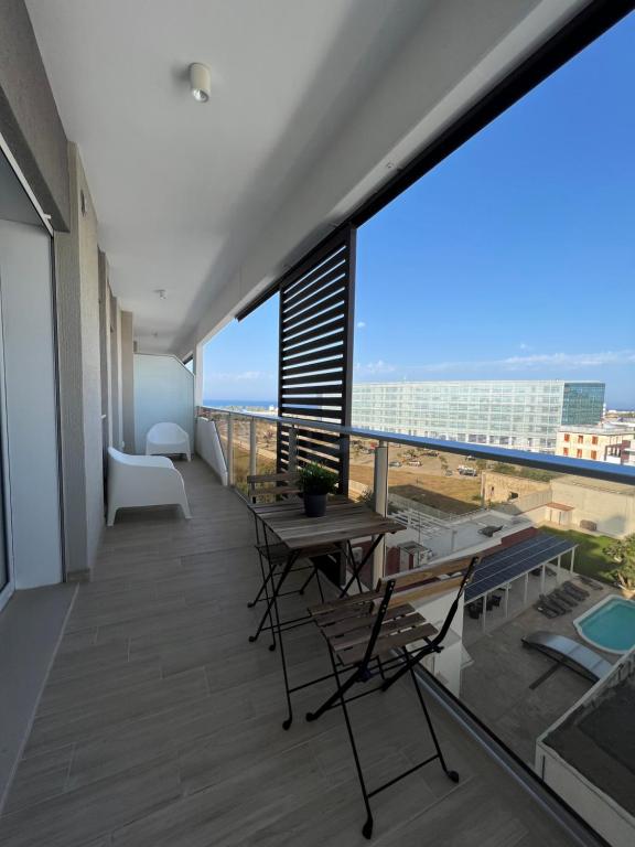 a balcony with tables and chairs and a view of the ocean at The Plus #4 HOWME in Bari