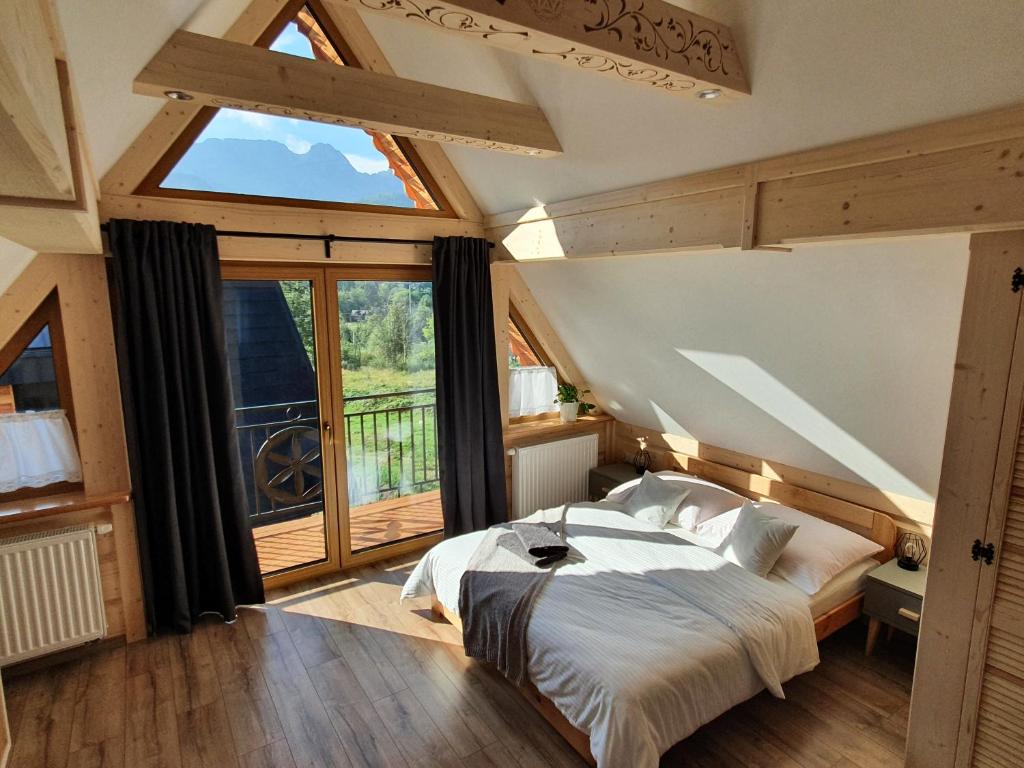 a bedroom with a bed and a large window at Domek Pana Jana in Zakopane