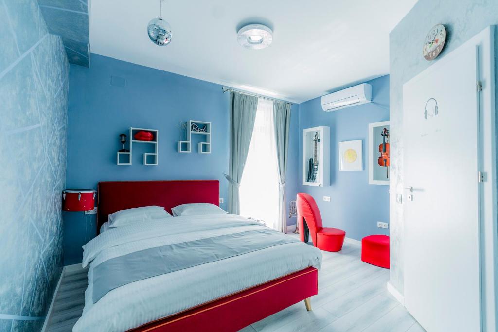 a blue bedroom with a bed and a red headboard at Catharsis House - self check in and self checkout in Oradea