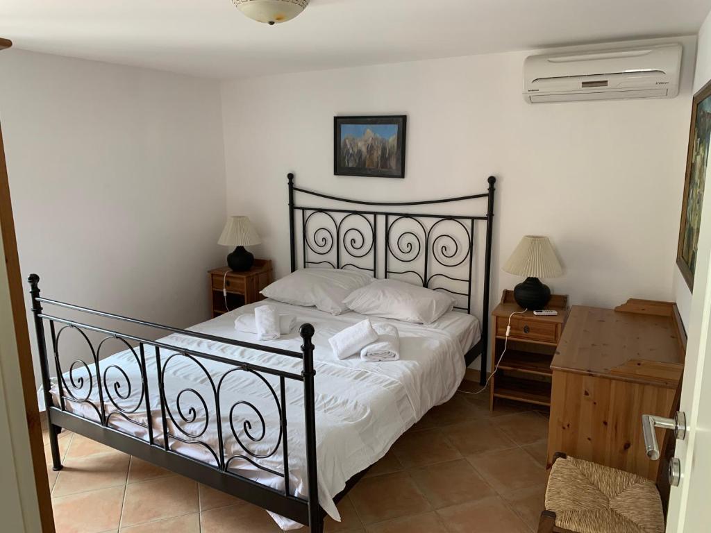 ein Schlafzimmer mit einem schwarzen Bett mit weißer Bettwäsche in der Unterkunft House Rozalia in Susak