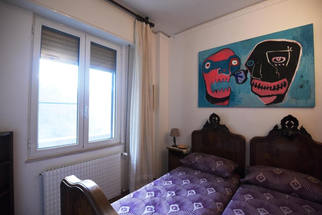 ein Schlafzimmer mit einem Bett und einem Fenster mit geschwungenen Schädeln in der Unterkunft B&B Tou Lì in San Martino