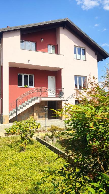 a red and white building with a balcony at Villa Fiorita in San Maurizio Canavese