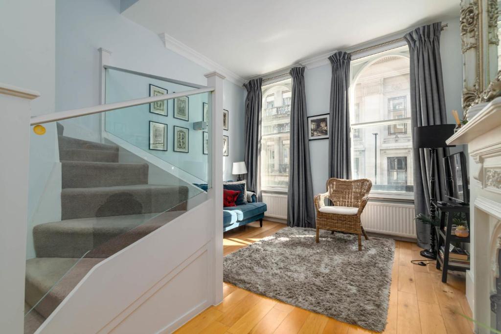 a living room with a staircase and a chair at GuestReady - Stunning Covent Garden 2BR Duplex in London