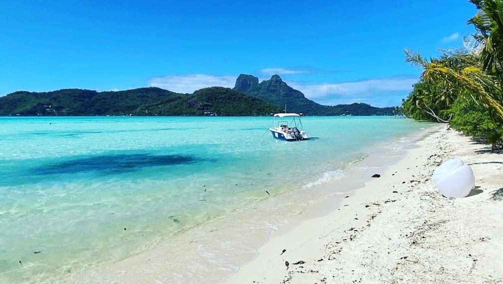 um barco na água em uma praia em ONLY YOU MOTU em Bora Bora