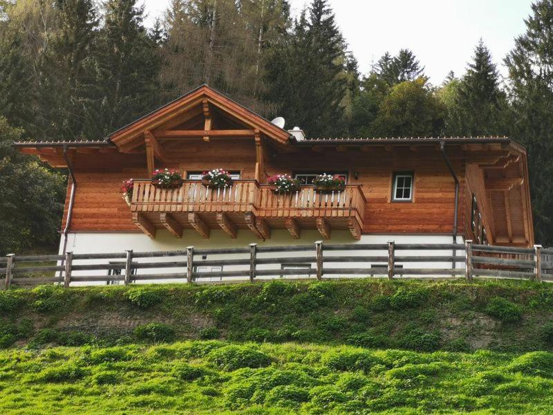 a log cabin with flower boxes on the balcony at Brücklerhof in Haus im Ennstal