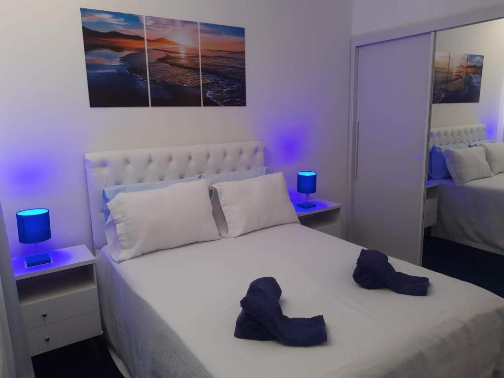 a bedroom with a bed with two shoes on it at Elegante Duplex Oceanico da Elena Super Cozinha USP y UfSCAR in São Carlos