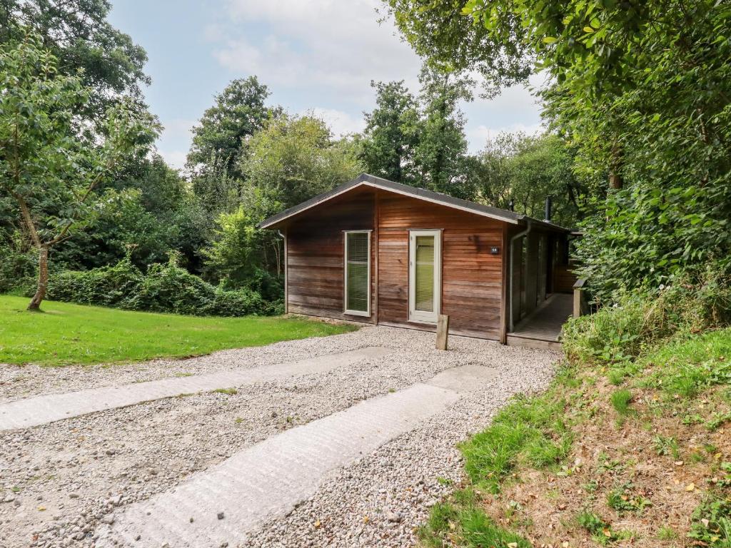 a small cabin in the woods with a gravel driveway at 9 Stonerush Valley in Looe