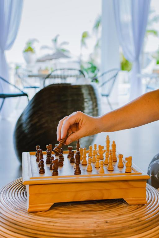 a person playing chess on a wooden chessboard at Residence Porto Ulisse in Parghelia