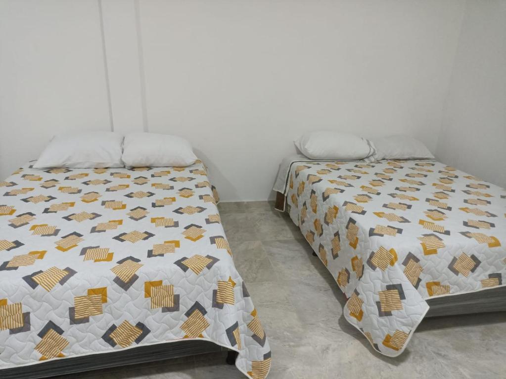 a bedroom with a bed with a quilt on it at Hotel Las Palmas de Puente Nacional in Puente Nacional