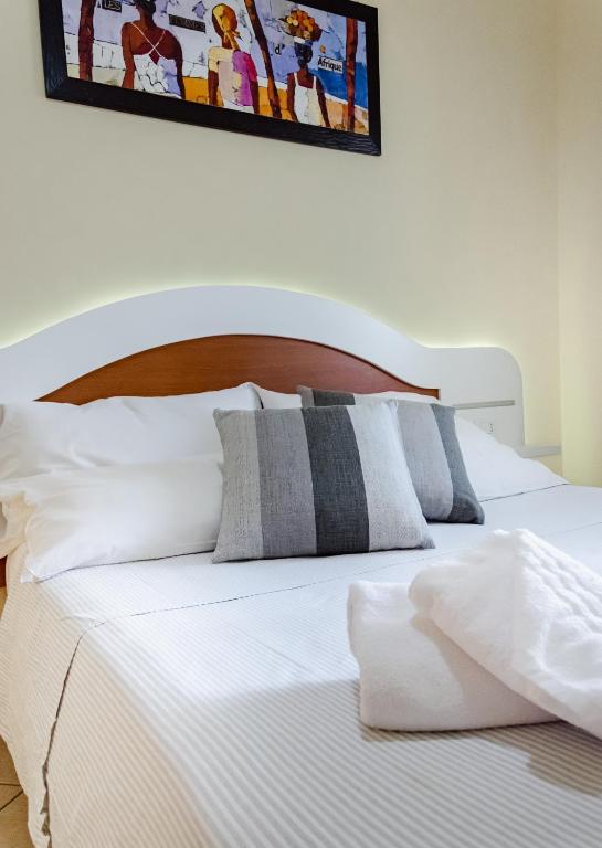 a bed with white sheets and pillows in a bedroom at Residence Porto Ulisse in Parghelia