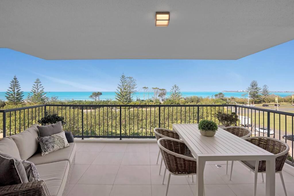 a patio with a couch and a table and chairs at Panoramic Ocean View 2 bed 2 bath in Alexandra Headland