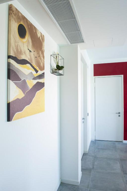 a hallway with a painting on the wall and a door at B&B Lough in Colà di Lazise