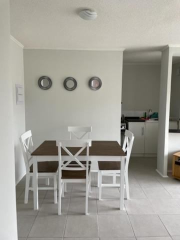 a dining room with a white table and chairs at Departamento Vista Aeropuerto in La Serena
