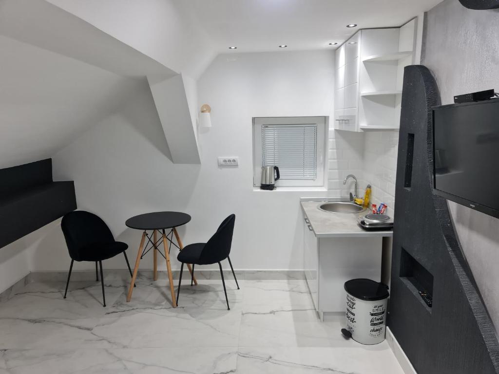 a kitchen with two chairs and a table and a sink at River side suites in Belgrade
