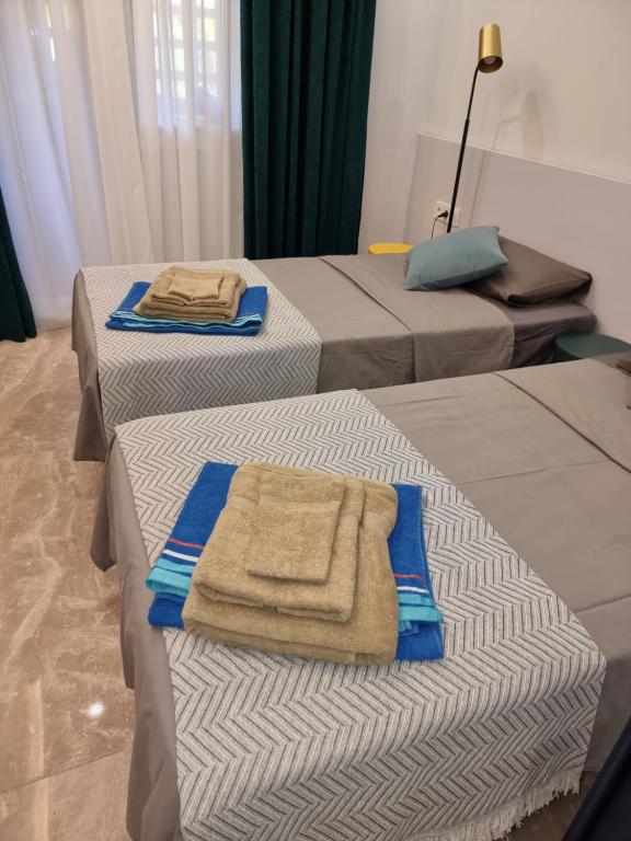 - une chambre avec 3 lits et des serviettes dans l'établissement Luxury apartment San Pedro de Alcantara, Marbella, near the Sea and Golf club, à Marbella