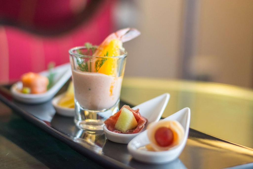 a tray with a drink and bowls of fruit on it at Sonesta St. George Hotel - Convention Center in Luxor
