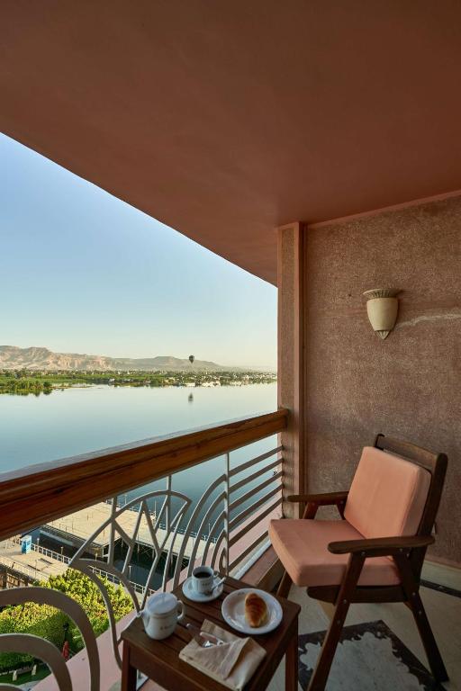 a room with a balcony with a view of the water at Sonesta St. George Hotel - Convention Center in Luxor