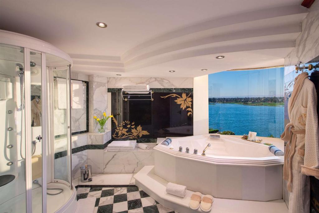 a large bathroom with a tub and a large window at Sonesta St. George Hotel - Convention Center in Luxor