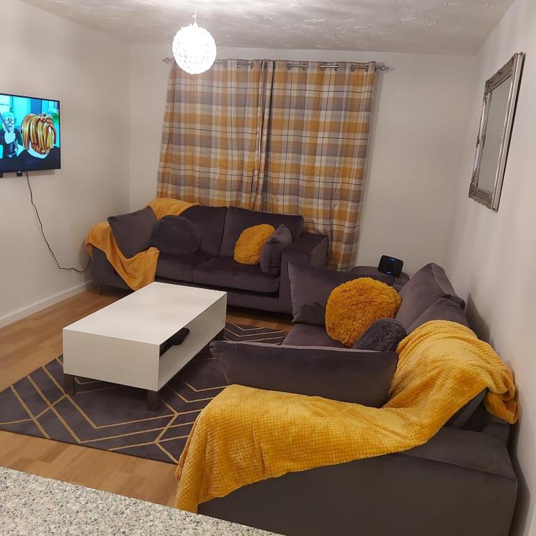a living room with a couch and a table at Lovely 2-Bed Apartment in Milton Keynes in Milton Keynes