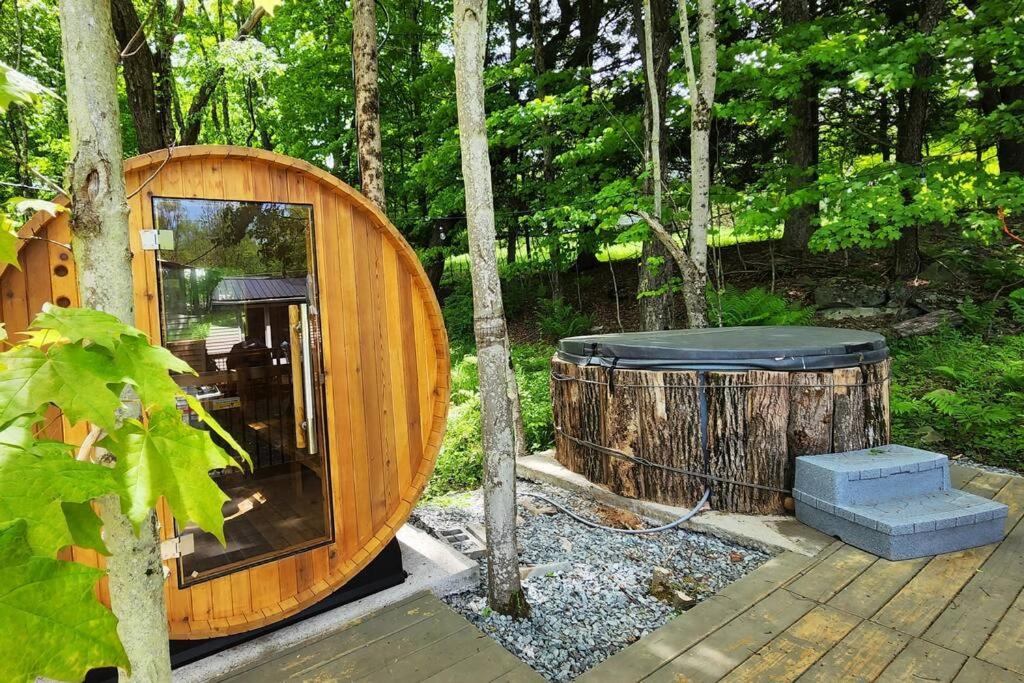 uma cabana de madeira redonda com um barril na floresta em NEW! Hurleyville Upstate NY - your Catskills getaway with hot tub, sauna and firepit! em Hurleyville