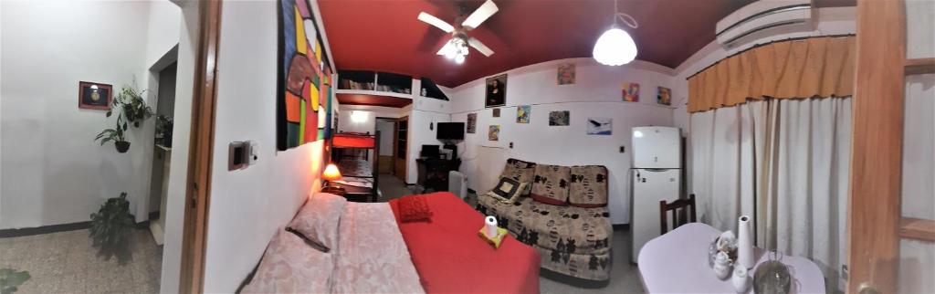 羅薩里奧的住宿－EnmicasaSSJ-Rosario，客厅配有红色沙发和冰箱
