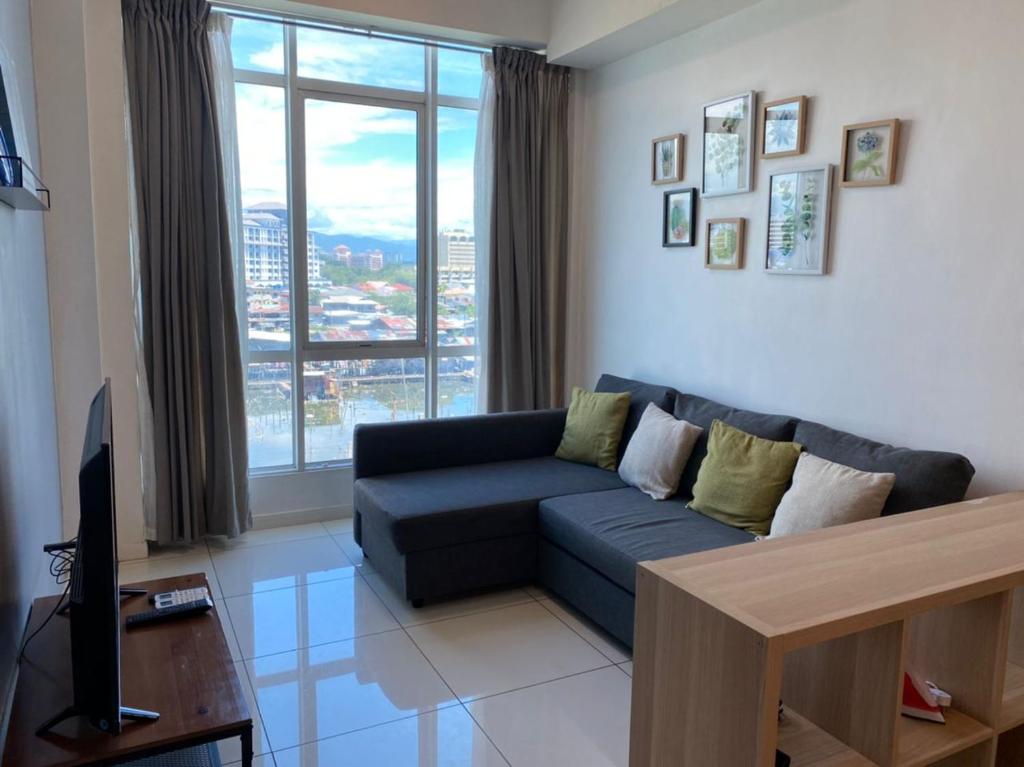 a living room with a couch and a large window at KK City Sutera Avenue Opposite Imago by JR Homestay in Kota Kinabalu