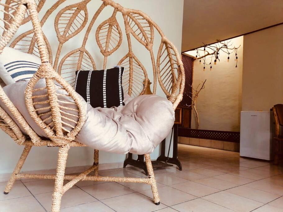 a wicker chair sitting in a living room at Cafeto Loft Lovely and private loft in Ruta de las Flores heart in Juayúa