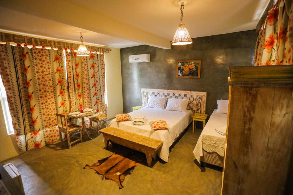 a bedroom with a bed and a table in it at Pousada Matuto Sonhador in Cabaceiras