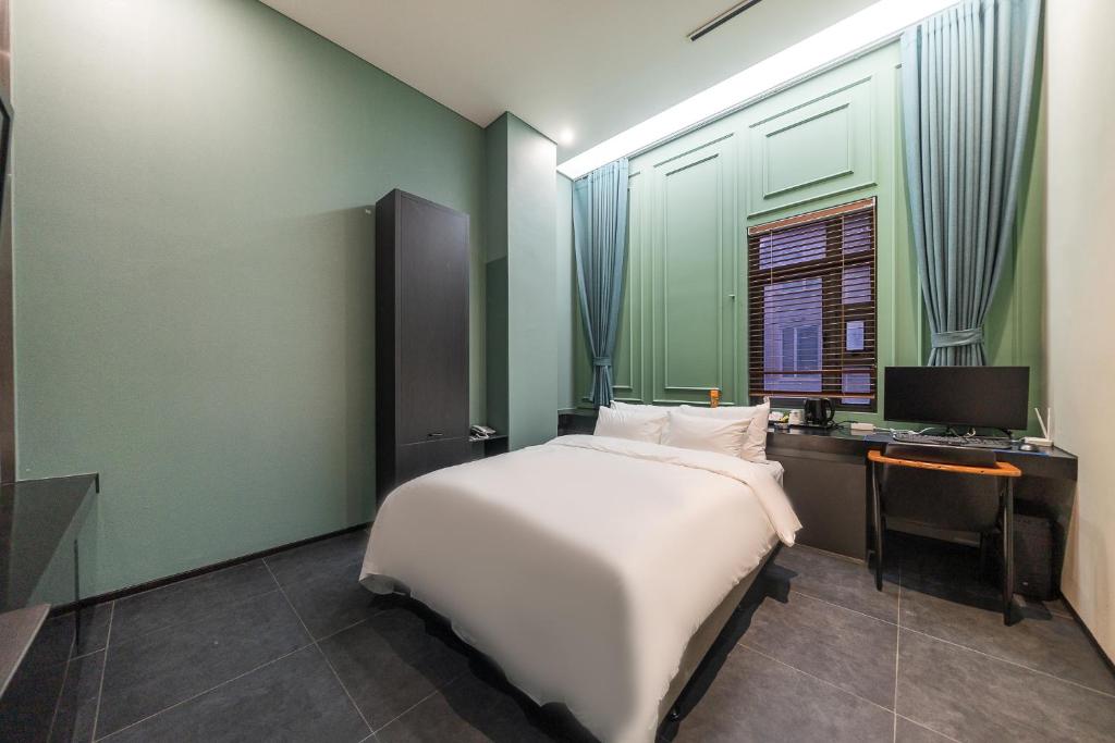 a bedroom with a bed and a desk and a television at Starhills Hotel in Seoul