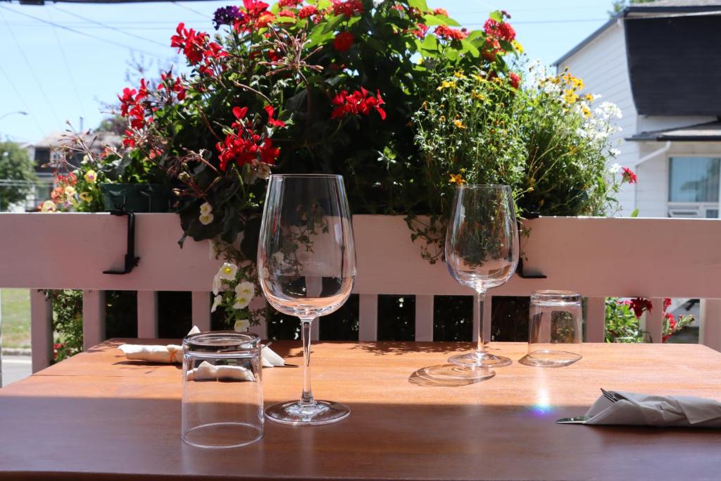 três copos de vinho sentados numa mesa de madeira com flores em Gîte du Pionnier em L'islet Sur Mer