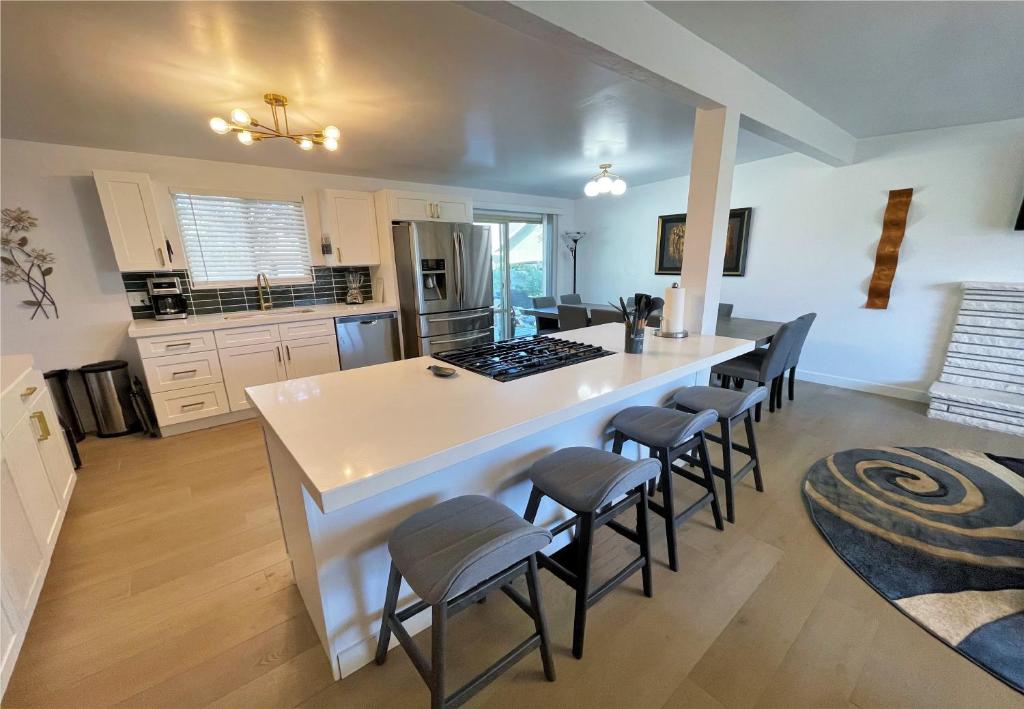 a kitchen with a large white island with bar stools at Modern 7-bedroom Home Near Downtown SLC in Millcreek