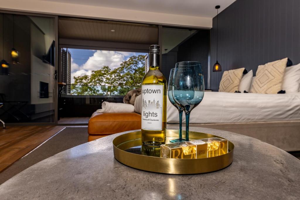 蒙特維爾的住宿－Luxury Spa Retreat with Ocean and Hinterland Views，一瓶葡萄酒和一杯酒在桌子上