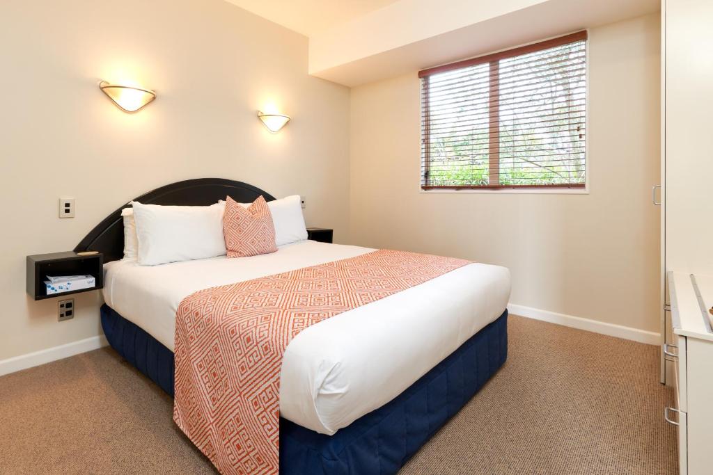 a bedroom with a bed and a window at Wine Country Motel Havelock North in Havelock North