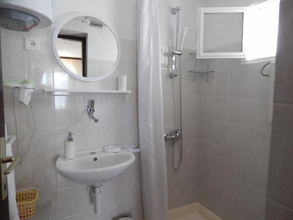 łazienka z umywalką i prysznicem z lustrem w obiekcie Apartments by the sea Okrug Donji, Ciovo - 17078 w mieście Okrug Donji