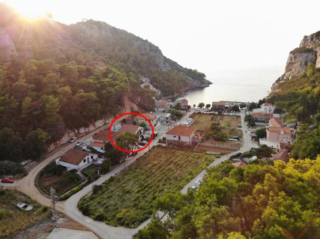widok z góry na dom z czerwonym krągiem w obiekcie Apartments by the sea Cove Vela Stiniva, Hvar - 17075 w mieście Zastražišće