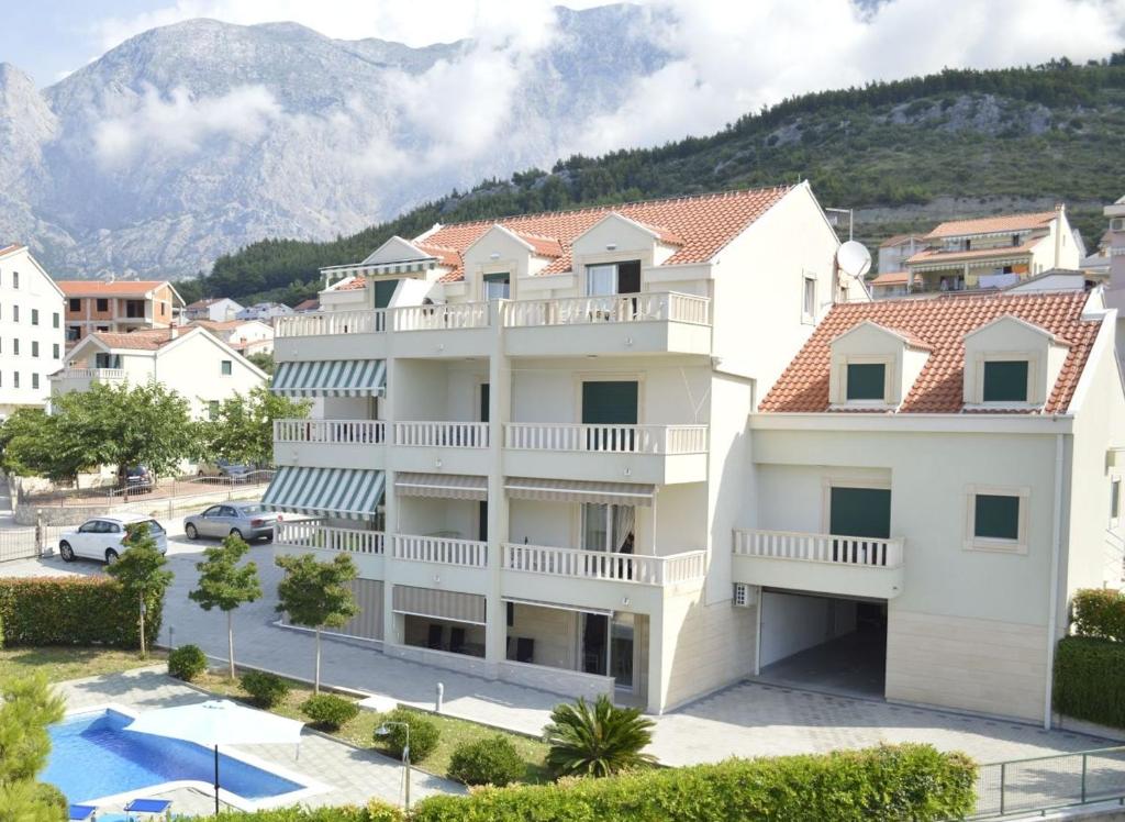 - un bâtiment blanc avec un balcon et une piscine dans l'établissement Apartments by the sea Promajna, Makarska - 17160, à Promajna