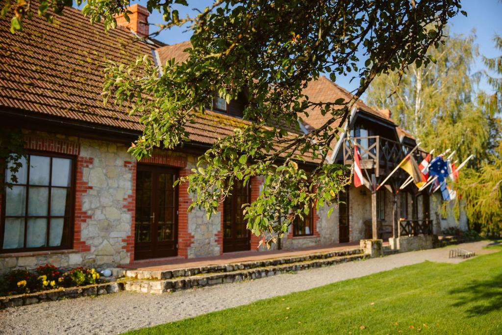 a brick house with american flags on it at Karlamuiza Country Hotel in Kārļi