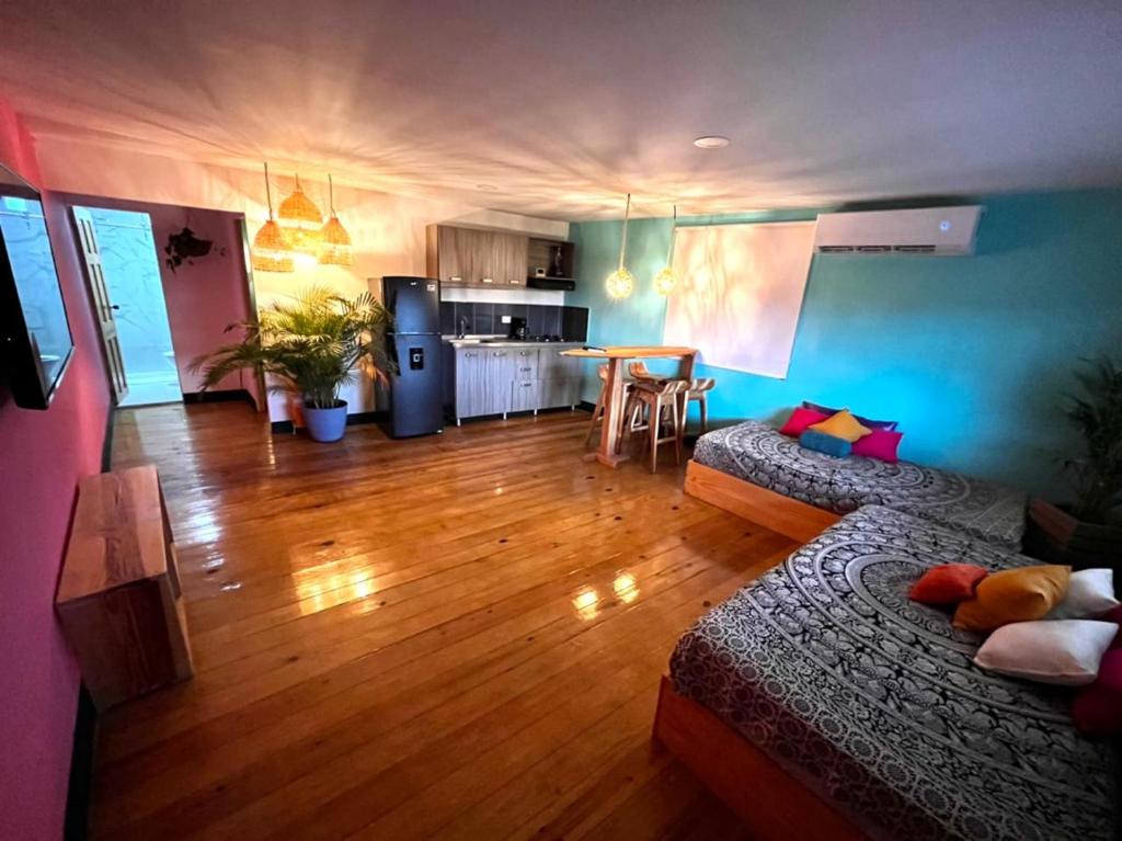 a living room with a couch and a kitchen at Be Happy Hotel in San Andrés