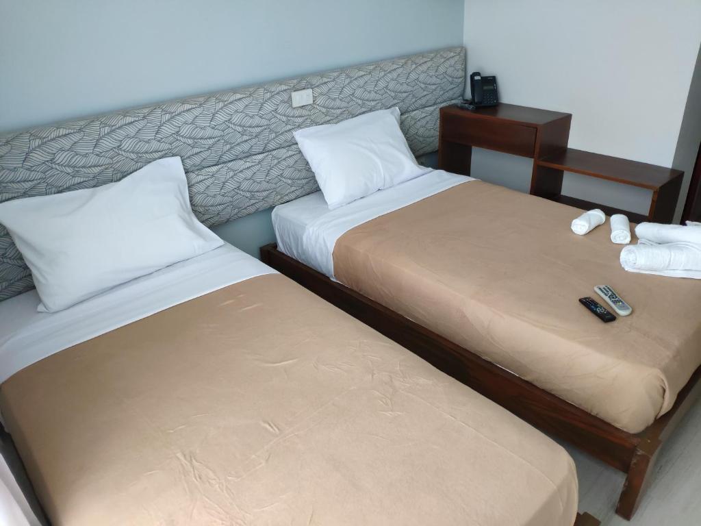 twee bedden naast elkaar in een kamer bij D' Loft Iligan in Iligan