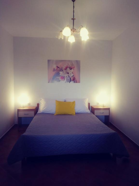 a bedroom with a bed with a yellow pillow at Apartments with a parking space Lopar, Rab - 17103 in Lopar