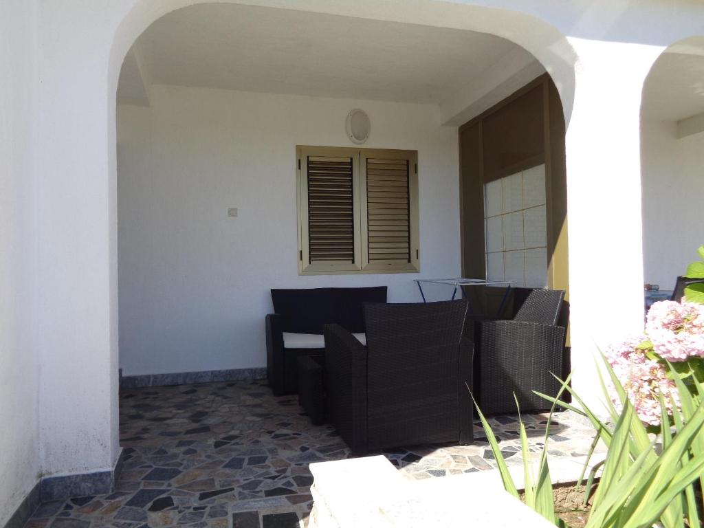 a patio with black chairs and a table at Apartments with a parking space Lopar, Rab - 17103 in Lopar