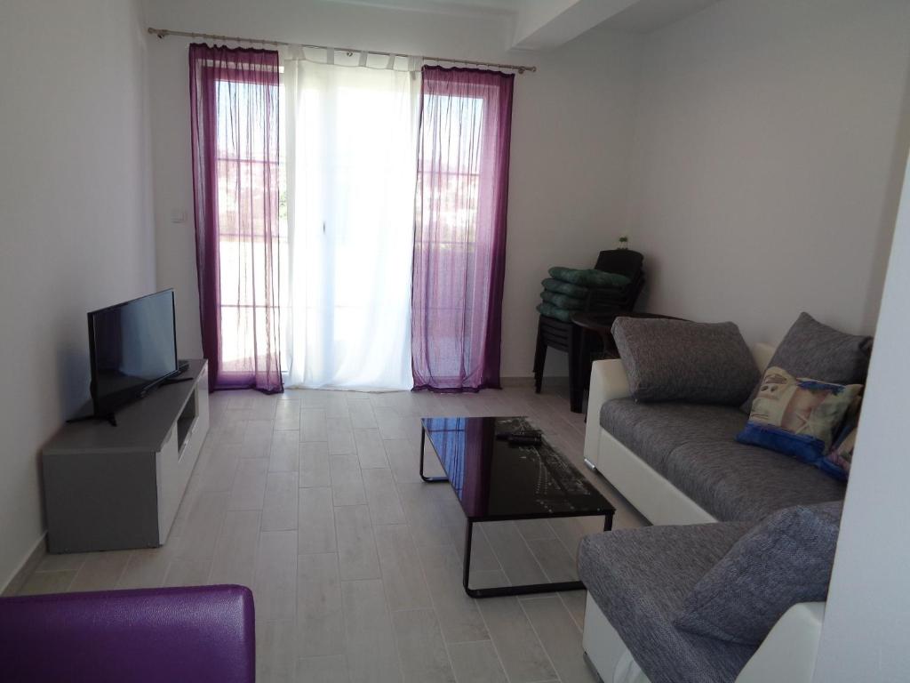 a living room with a couch and a tv at Apartments with a parking space Lopar, Rab - 17103 in Lopar