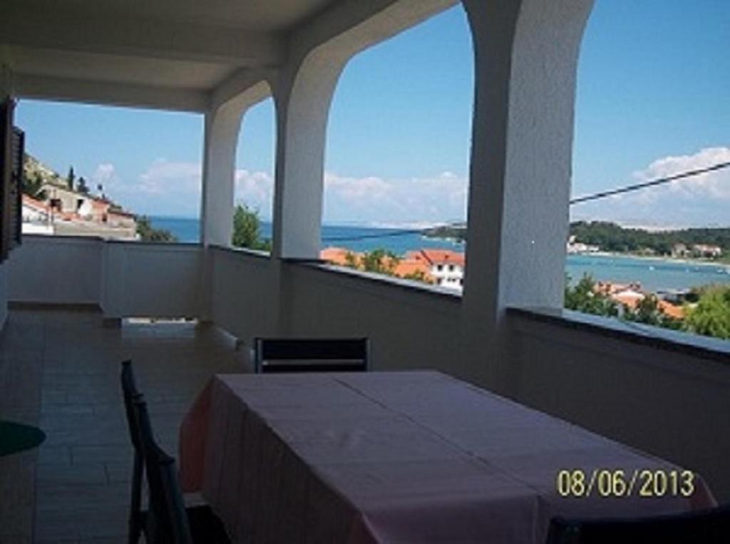 a room with a table and views of the water at Apartments with a parking space Lopar, Rab - 17103 in Lopar