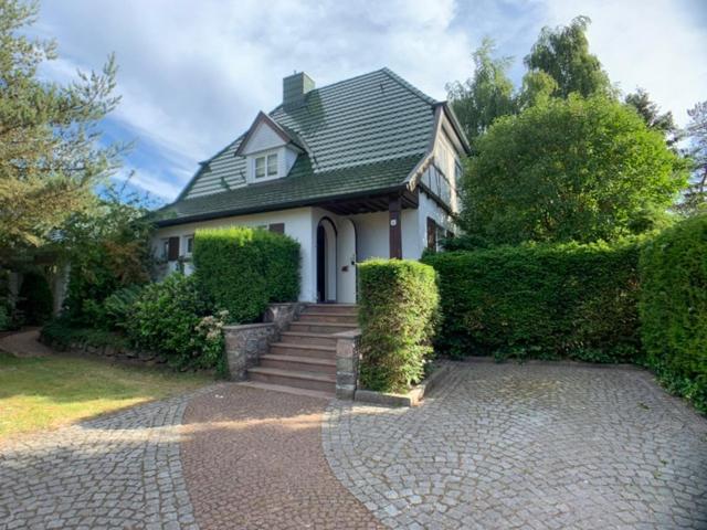 een wit huis met een groen dak en een trap bij Top Lage! Charmantes Landhaus 5 Geh-Min v. Strand in Timmendorfer Strand