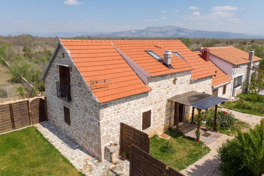 an aerial view of a stone house with an orange roof at Family friendly house with a swimming pool Bogatic, Krka - 17168 in Oklaj