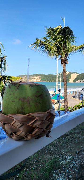 een grote watermeloen op een tafel naast een strand bij Suíte beira mar em Ponta Negra - Residencial Ponta Negra Beach in Natal