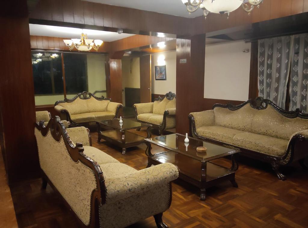 a living room with couches and tables in a room at Hotel De Villa Gangtok in Gangtok