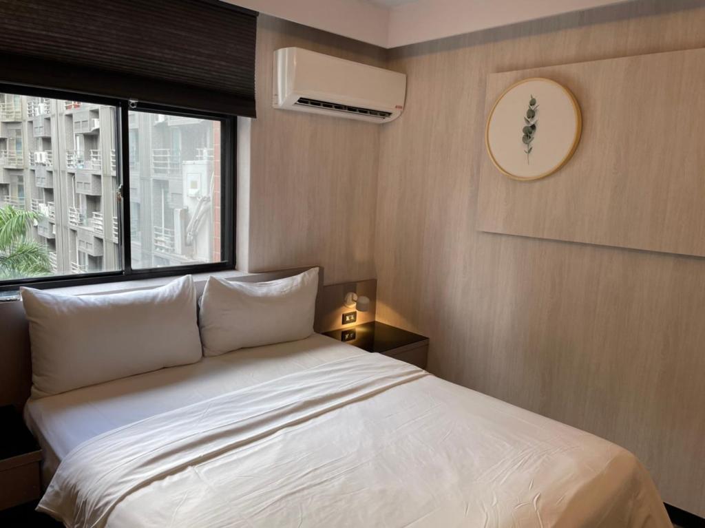a bedroom with a white bed and a window at Sunrise Hotel in Taipei